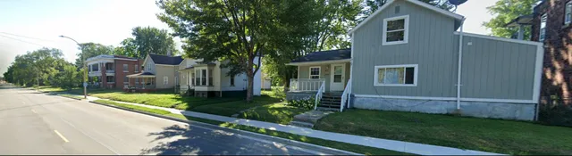a view of a house with backyard and a tree