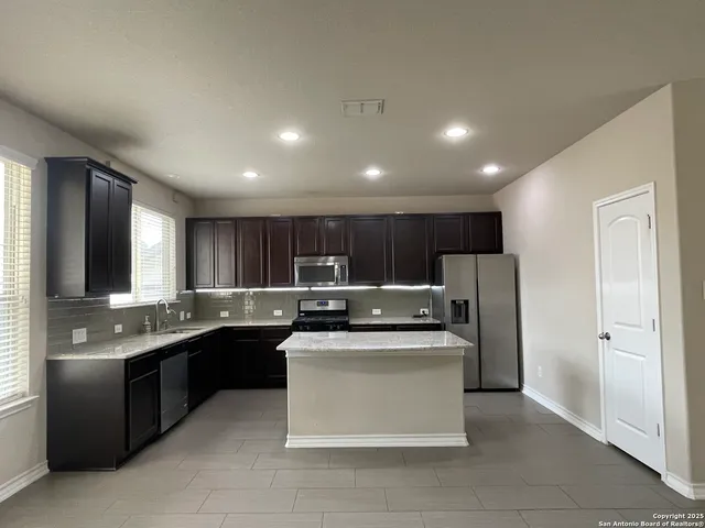 a kitchen with stainless steel appliances granite countertop a sink counter space and refrigerator
