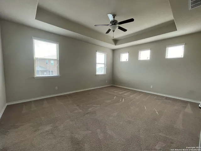 an empty room with a window and a fan