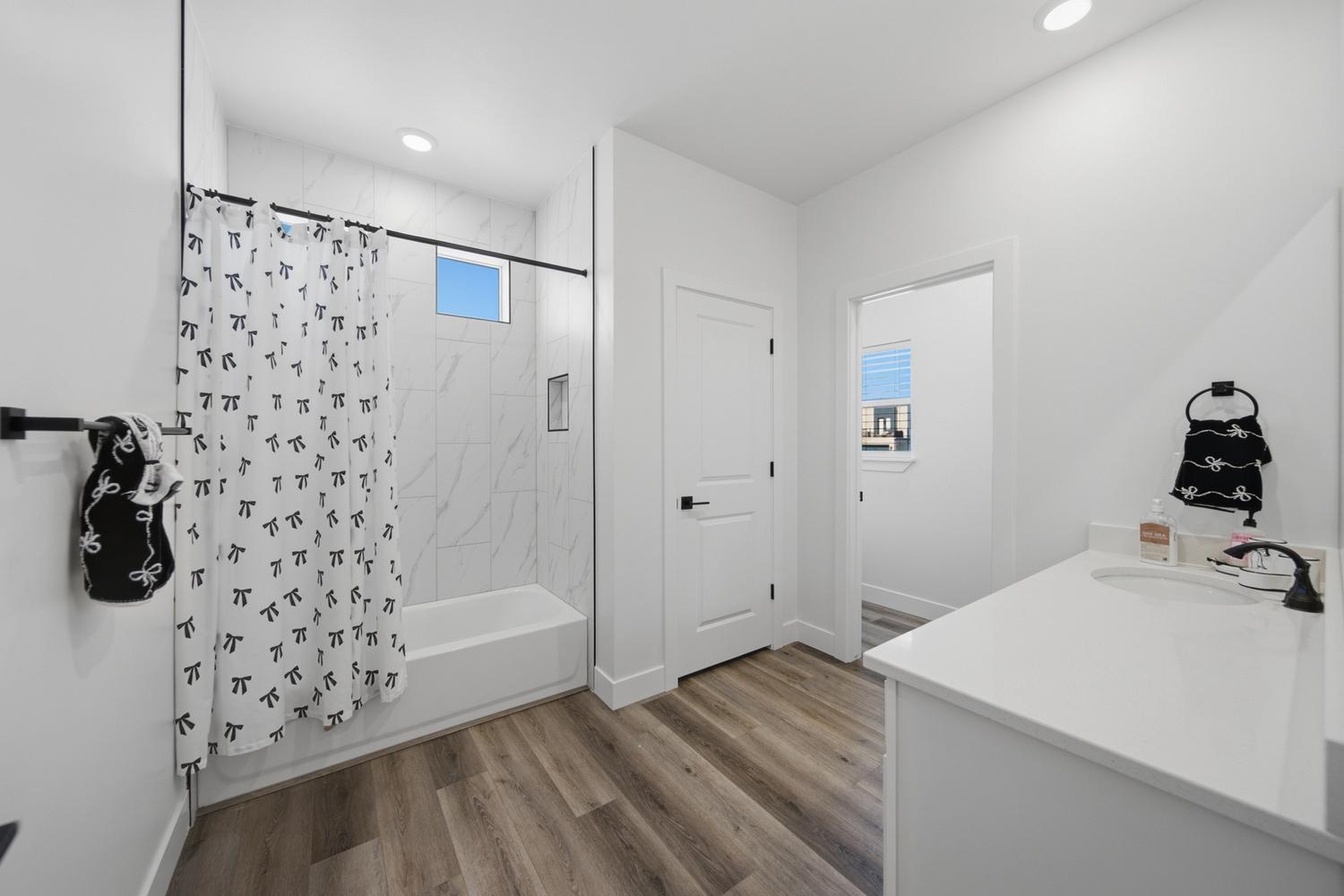 6144 Red Sand Lane St. George, UT 84790 - Photo 16 of 19 A tub-shower combo finished in marble-look tile offers everyday flexibility in this well-proportioned bath, complete with a transom window for natural light and brushed-nickel fixtures throughout. Neighboring doors lead to a private water closet and additional living space, making this an efficient, functional layout.