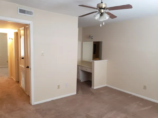 an empty room and chandelier fan in a room