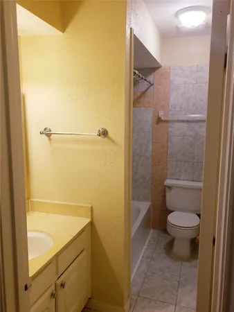 a bathroom with a granite countertop toilet and a shower
