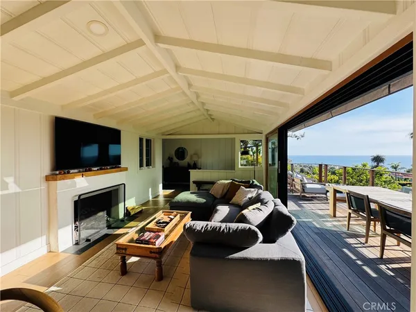 a living room with furniture a flat screen tv and a large window