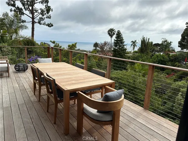 a view of a patio with couches table and chairs with wooden floor and fence