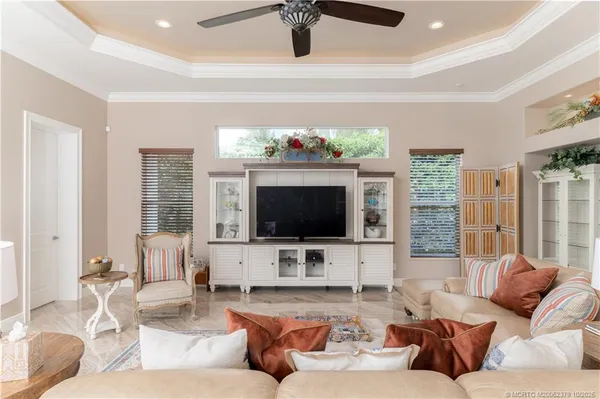 a view of a white house with a yard potted plants and a table