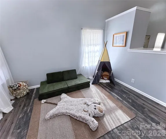a living room with furniture chess board and a window