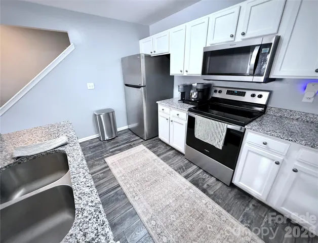 a kitchen with a stove a sink and a microwave