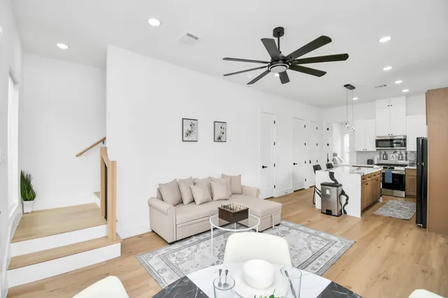 a living room with furniture and a view of kitchen