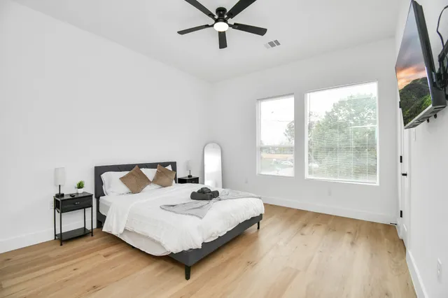 a bedroom with a bed and wooden floor