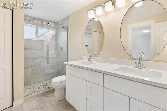 a bathroom with a double vanity sink mirror and toilet