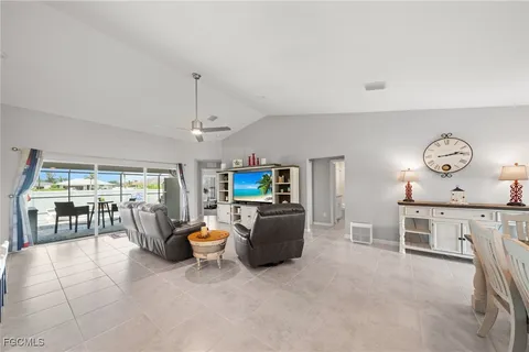 a living room with furniture a chandelier and kitchen view