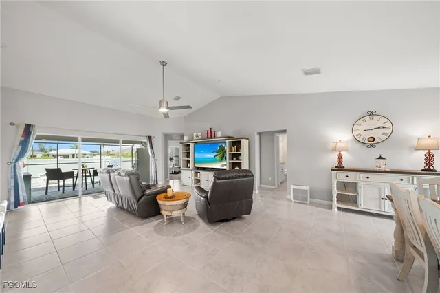 a living room with furniture a chandelier and kitchen view