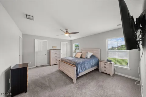 a spacious bedroom with a bed and a flat screen tv