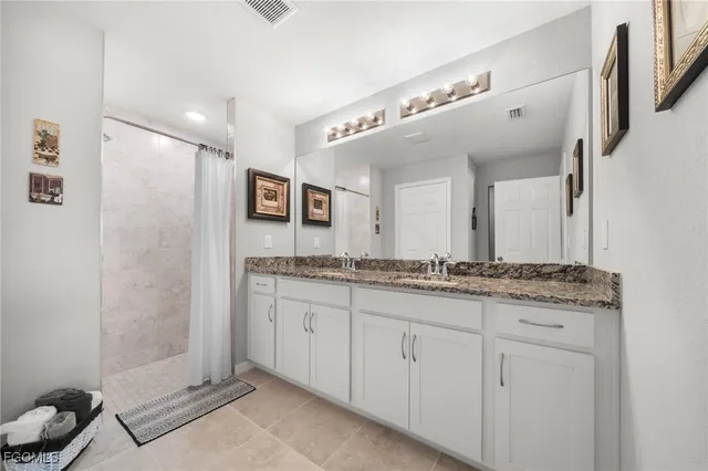 a bathroom with a granite countertop sink a mirror and a shower