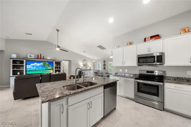 a kitchen with stainless steel appliances granite countertop a sink and a stove