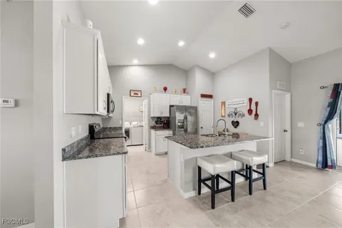 a kitchen with stainless steel appliances kitchen island granite countertop a sink and cabinets