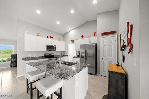 a kitchen with stainless steel appliances granite countertop a sink refrigerator and microwave