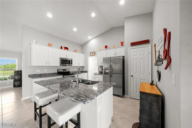 a kitchen with stainless steel appliances granite countertop a sink refrigerator and microwave