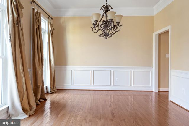 a view of empty room with wooden floor and windows