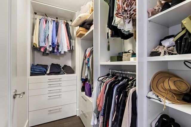 a view of walk in closet with clothes and shoes