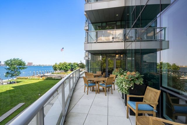 a view of a roof deck with table and chairs and wooden floor