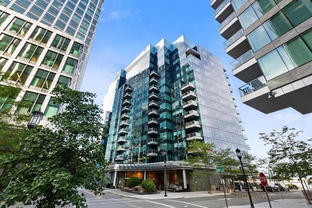 a view of a large building with garden space and trees in the background