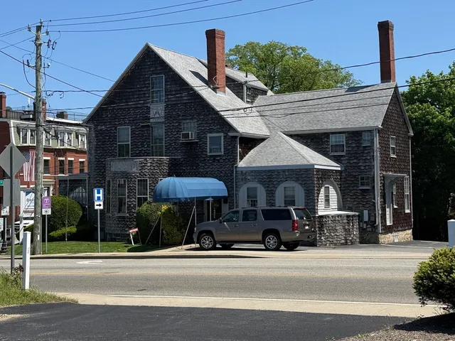 a man walking down a street next to a building