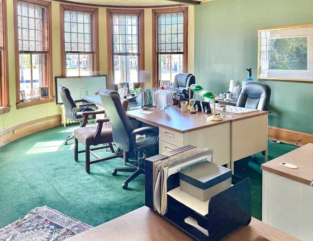 a view of a dining room with furniture a rug and wooden floor