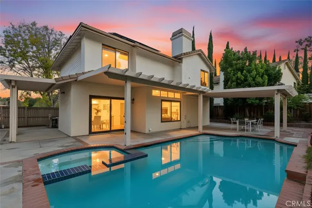 a view of a house with pool and chairs