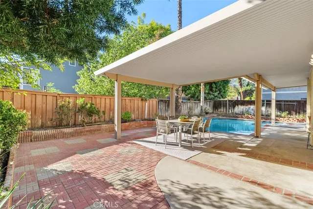 a view of a patio with table and chairs with wooden floor and fence