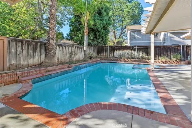 a view of a backyard with table and chairs and wooden fence