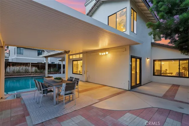 a view of a backyard with couches plants and large tree