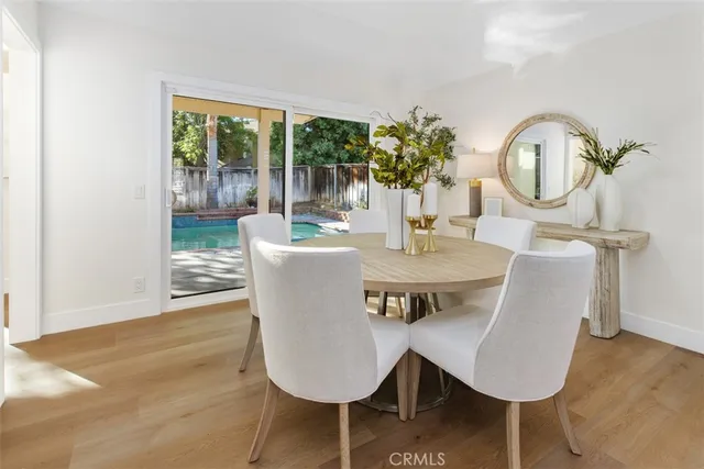 a dining room with furniture a potted plant and wooden floor