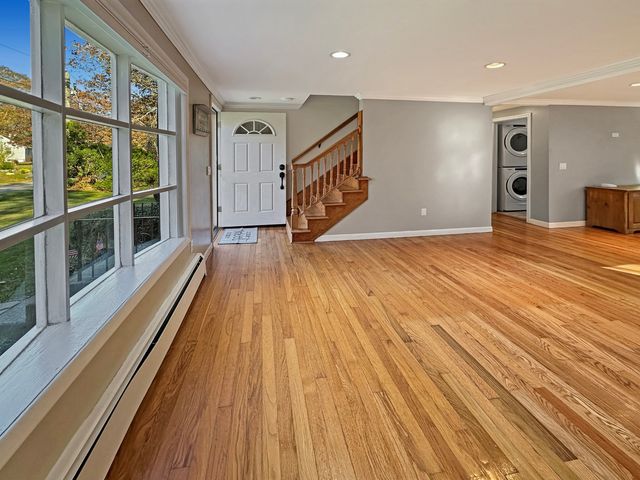 a view of an empty room with furniture and a window