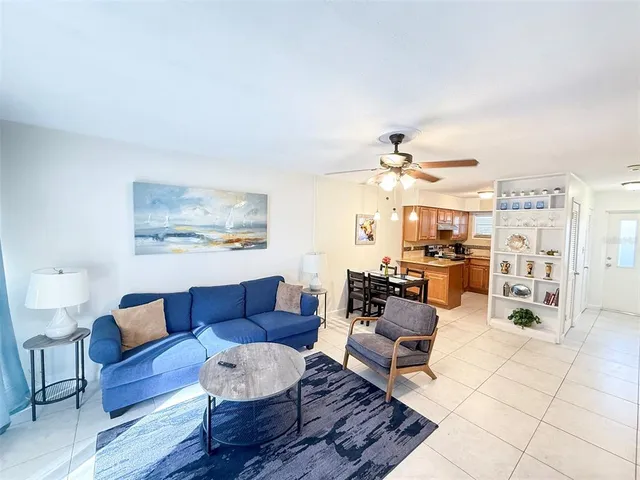 a living room with furniture kitchen view and a chandelier