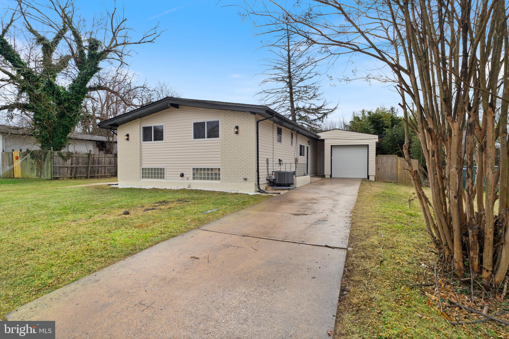 a view of a white house with a big yard and large trees
