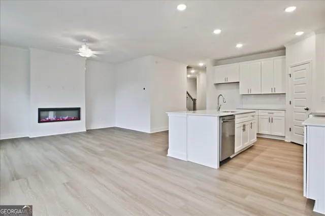 a kitchen with a sink cabinets and wooden floor