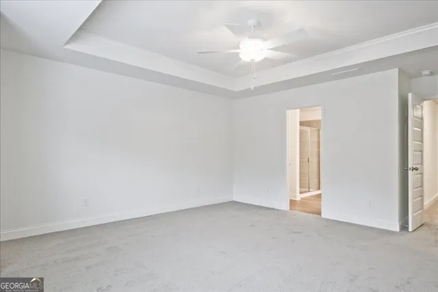 an empty room with a ceiling fan and window
