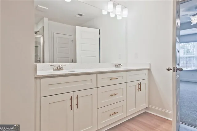 a bathroom with double vanity sink a vanity and mirrors