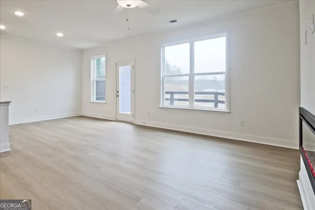 an empty room with wooden floor and windows