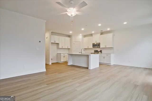 a view of kitchen with granite countertop cabinets and refrigerator