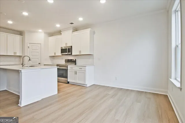 a kitchen with white cabinets and white appliances