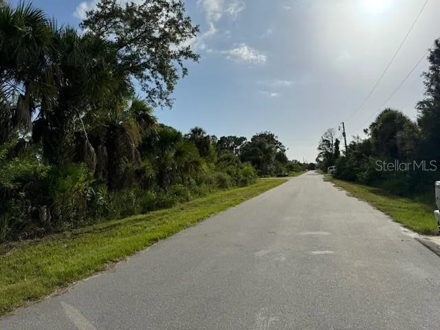 a view of a street both side of grassy field