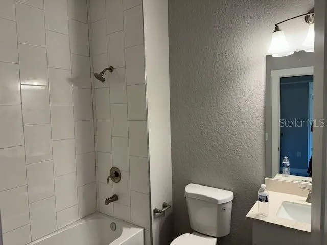 a white toilet sitting next to a bath tub