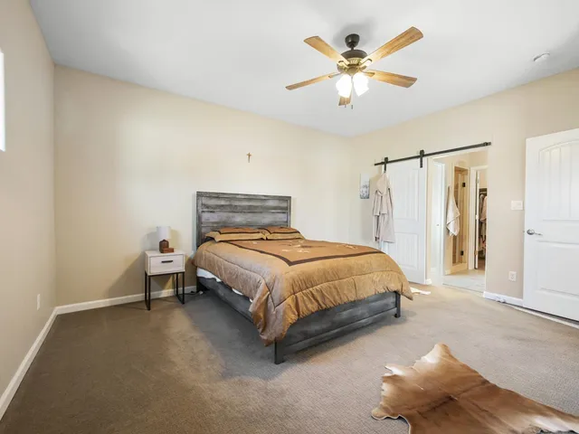 a bedroom with a bed and a ceiling fan