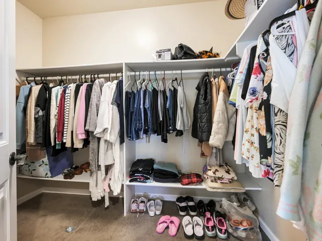a view of walk in closet with clothes and shoes