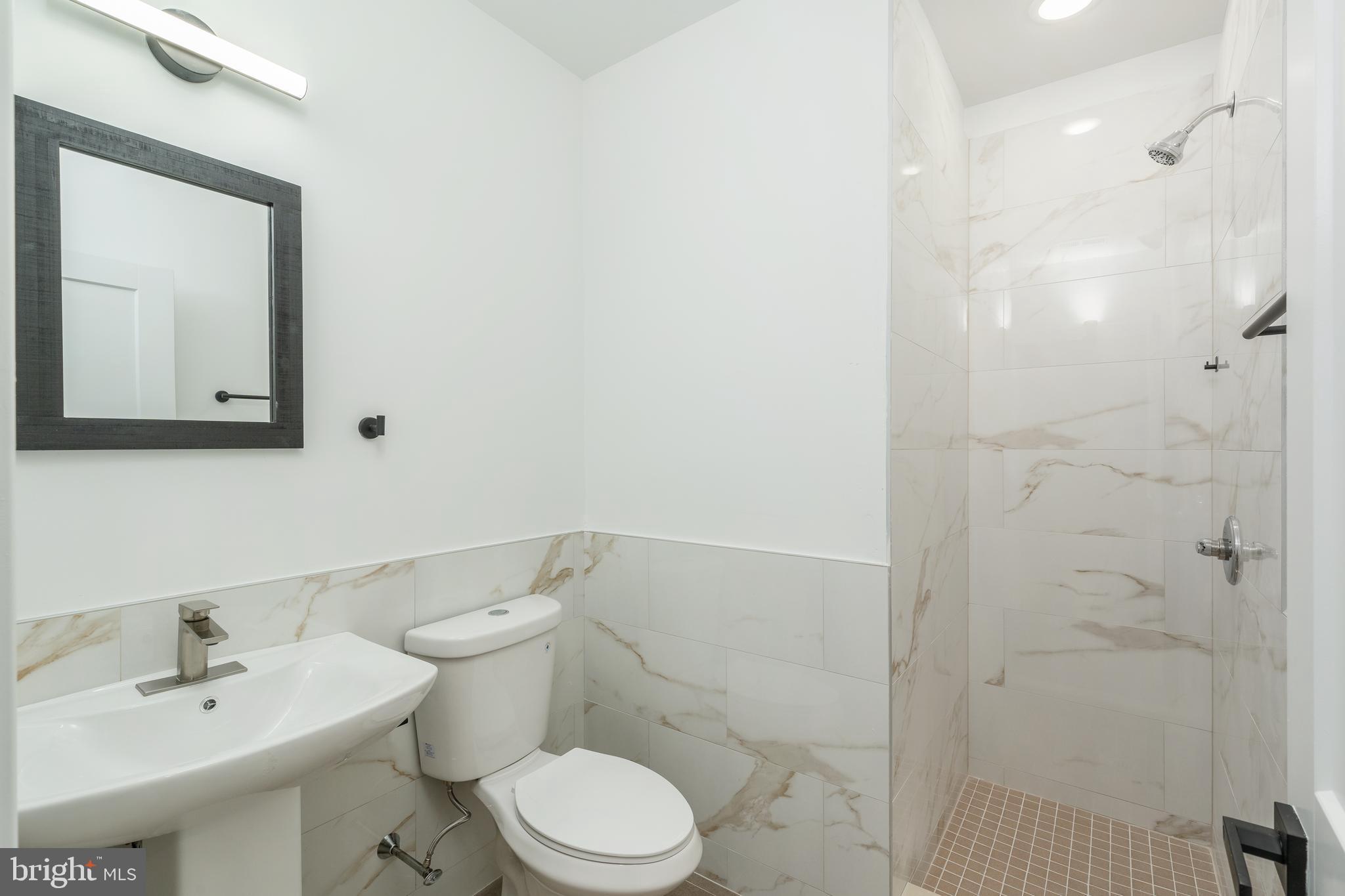 4111 Parrish Street Philadelphia, PA 19104 - Photo 14 of 38 a bathroom with a toilet a sink a shower and mirror