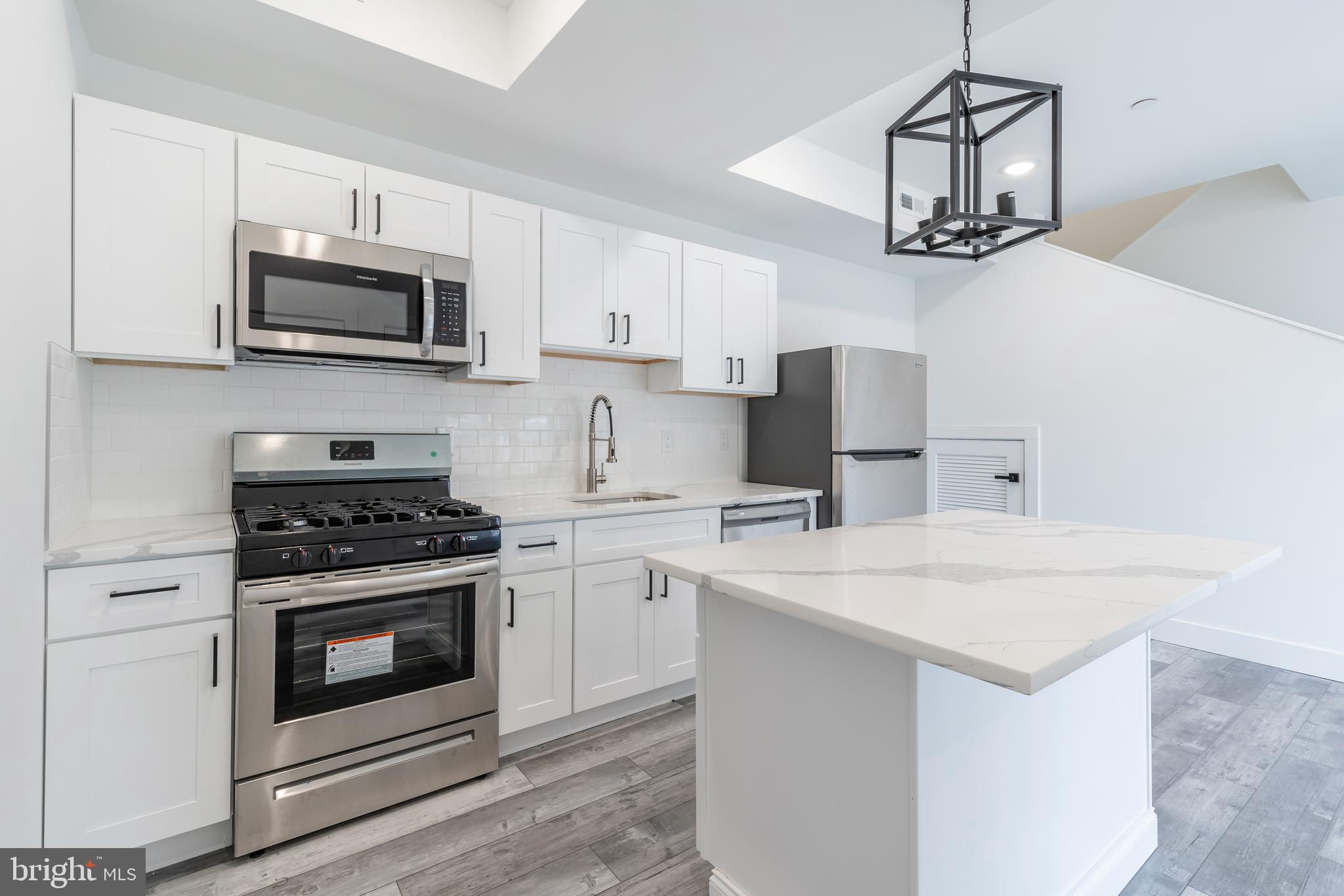 4111 Parrish Street Philadelphia, PA 19104 - Photo 27 of 38 a kitchen with stainless steel appliances a sink a stove a microwave and cabinets