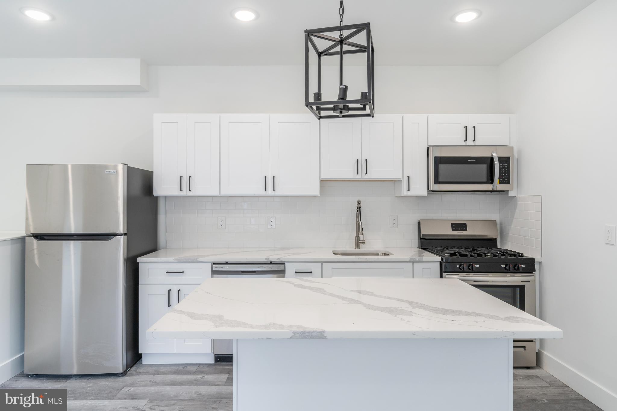 4111 Parrish Street Philadelphia, PA 19104 - Photo 6 of 38 a kitchen with stainless steel appliances a refrigerator a stove a microwave a sink and cabinets