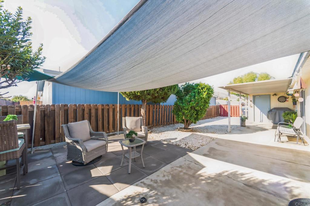 27250 Murrieta Road, Unit 364 Menifee, CA 92586 - Photo 15 of 17 a view of a patio with table and chairs potted plants and a large tree
